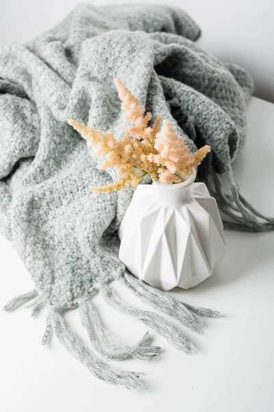 Small bouquet of flowers in vase with blanket — Stock Photo, Image