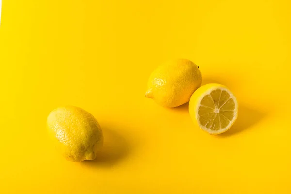 노란색 배경에 천연 신선한 육즙 레몬 — 스톡 사진