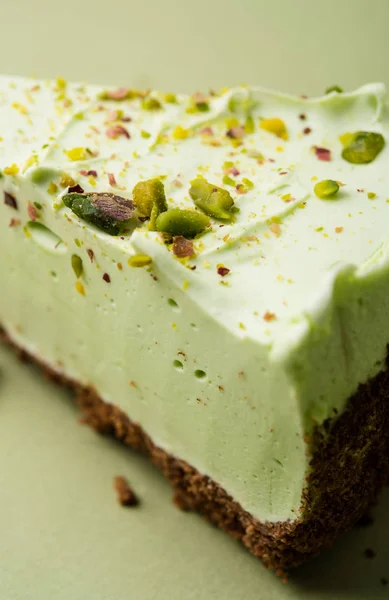 One slice of pistachio cheesecake on sight green background — Stock Photo, Image