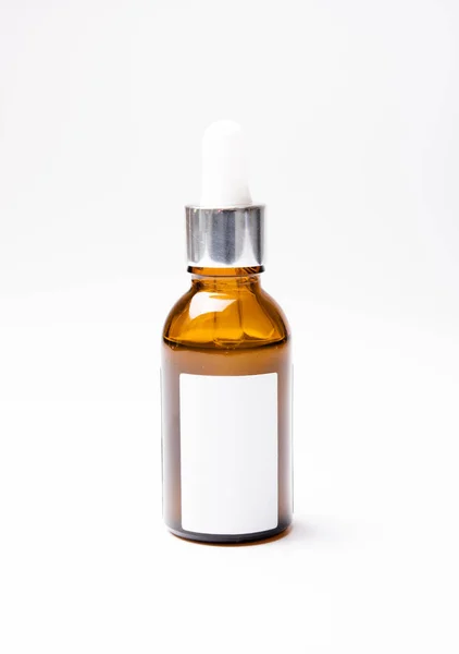 Brown glass cosmetic bottle mock-up with blank white label — Stock Photo, Image