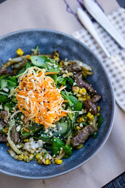 Comida asiática, ensalada de verduras con carne asada en plato de cerámica —  Fotos de Stock