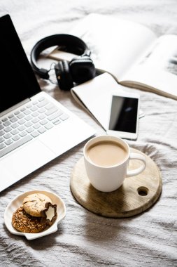 Gerçek ev işyeri, bir fincan kahveli dizüstü bilgisayar, sıcak battaniyeli kurabiye.