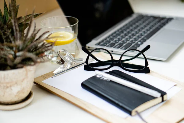 Home office with laptop, plants and glasses — Stock Photo, Image