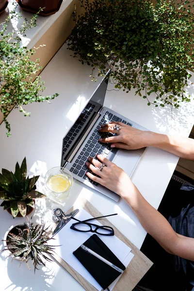 Mujeres manos en el teclado portátil, acogedor lugar de trabajo —  Fotos de Stock