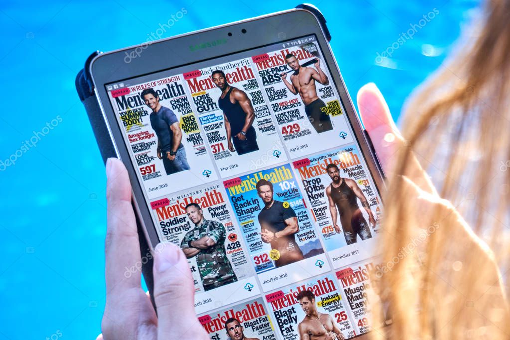 MONTREAL, CANADA - SEPTEMBER 8, 2018: Mens Health magazines on a Samsung Galaxy tablet in hands.