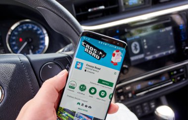 Montreal, Kanada - 8 Ağustos 2018: Crossy Road android Samsung s8 ekranda video oyunu hareket eden bir adamın elinde bir araba.