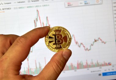 Montreal, Kanada - 8 Eylül 2018: Bitcoin altın kripto para sikke bitcoin grafikte bir masaüstü ekran üzerinde bir elinde tutan bir el.