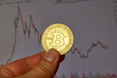 Montreal, Kanada - 8 Eylül 2018: Bitcoin altın kripto para sikke bitcoin grafikte bir masaüstü ekran üzerinde bir elinde tutan bir el.