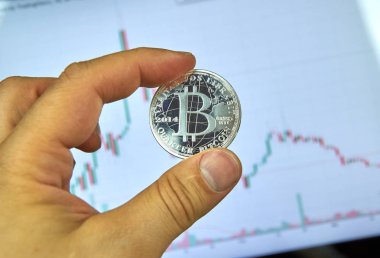 Montreal, Kanada - 8 Eylül 2018: Bitcoin gümüş kripto para birimi para bitcoin grafikte bir masaüstü ekran üzerinde bir elinde tutan bir el.