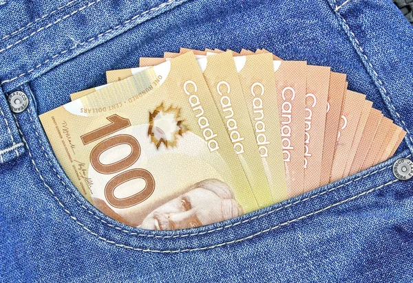 canadian money in a pocket of a blue jeans