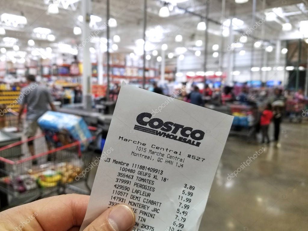 MONTREAL, CANADA - OCTOBER 5, 2018: A hand holding a receipt with the brand name and logo in Costco warehouse. Costco is an American corporation which operates a chain of membership only warehouses.