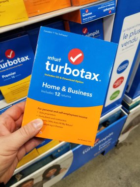 MONTREAL, CANADA - SEPTEMBER 8, 2018: A hand holding TurboTax package. TurboTax is an American tax preparation software which includes multiple packages for home, business as well as free edition. clipart