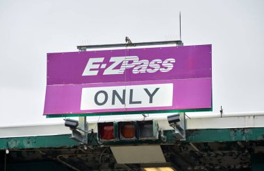NEW YORK, USA - DECEMBER 14, 2018: EZPass only sign. E ZPass is electronic toll collection system used on tolled roads, tunnels and bridges, and tunnels in the United States clipart