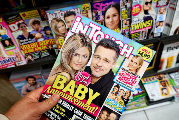 Журнал In Touch в руке
