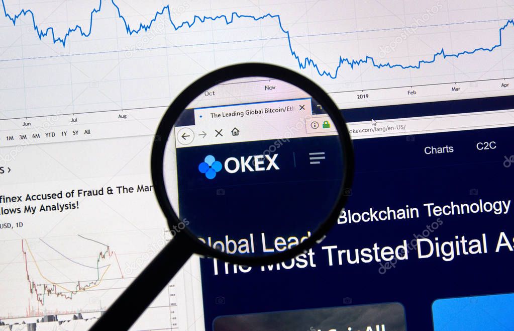 MONTREAL, CANADA - APRIL 26, 2019: OKEX cryptocurrency digital assets exchange logo and home page on a laptop screen under magnifying glass.