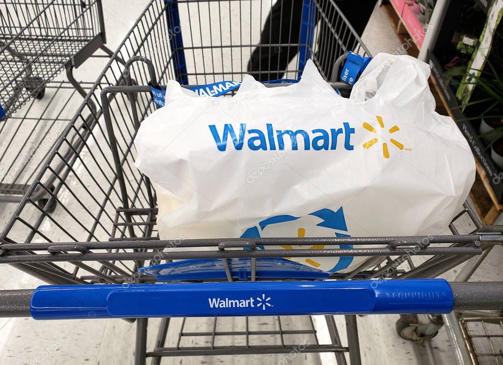 MONTREAL, CANADA - APRIL 30, 2019: Branded Walmart shopping cart and bag in Walmart store. Walmart is an American retail corporation that operates a chain of hypermarkets and discount department stores