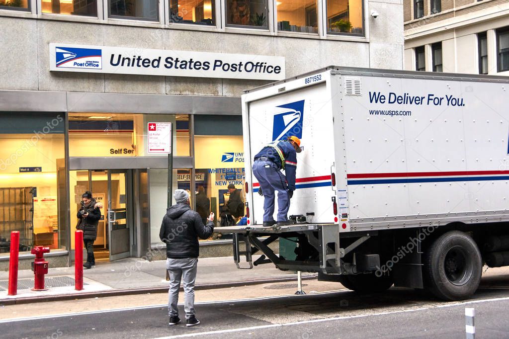 NEW YORK, USA - DECEMBER 14, 2018: USPS postman on a mail delivery truck in New York. USPS is an independent agenc of US federal government responsible for providing postal service in the US.