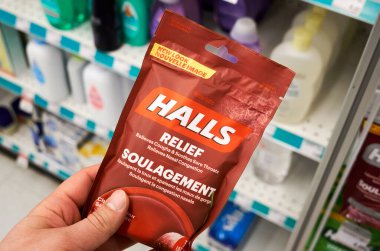 Montreal, Canada - May 03, 2020: Halls Mentho Lyptus drops pack in a hand. Halls is the brand name of a popular mentholated cough drop. Halls cough drops are sold by the Cadbury Adams