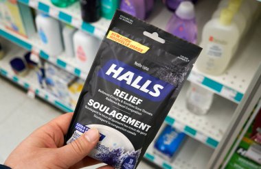 Montreal, Canada - May 03, 2020: Halls Mentho Lyptus drops pack in a hand. Halls is the brand name of a popular mentholated cough drop. Halls cough drops are sold by the Cadbury Adams