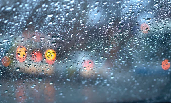 雨の夜にバス停で車のライトがついている ストックフォト