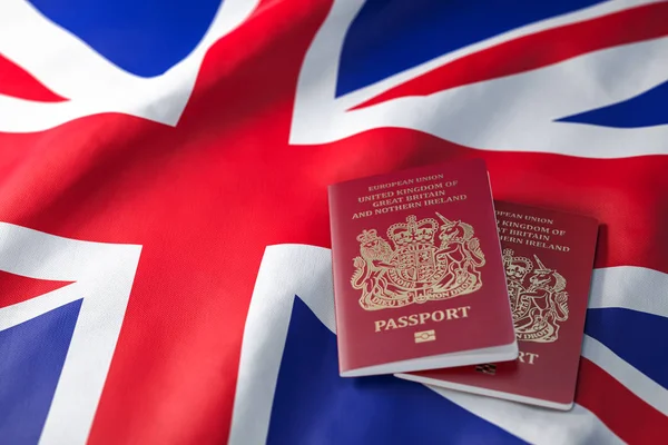 UK passport on the flag of the United Kingdom. Getting a UK passport,  naturalization and immigration concept. 3d illustration