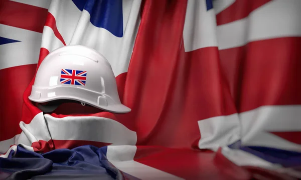 White hard hat laying over UK  flag. Construction and employment — 스톡 사진