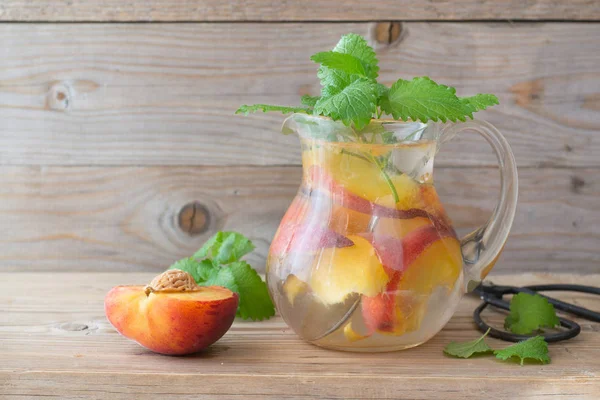 Peach infused water in pitcher