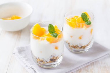 Yoğurt, granola ve portakal.