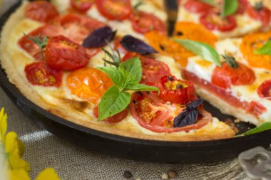 Domates tart shortcrust pasta, kırmızı ve sarı domates, peynir ve krema ile yapılır. Rustik ahşap arka plan üzerinde sağlıklı beslenme veya vejetaryen gıda kavramı