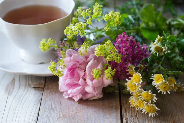 Φλιτζάνι Τσάι Και Λουλούδια Στο Τραπεζι Ξυλινο — Φωτογραφία Αρχείου