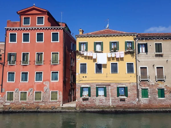 Colorful houses with drying clothes  near canal in Venice, Italy