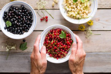 Ahşap masada kırmızı, beyaz ve siyah frenk üzümü.