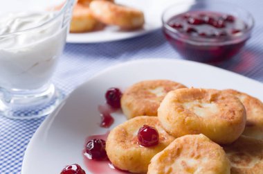 Süzme peynir kek kiraz ile beyaz seramik plaka reçel