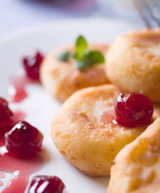 Süzme peynir kek kiraz ile beyaz seramik plaka reçel. Seçici odak.