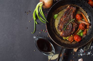 bir tava üzerinde sebzeli ızgara biftek