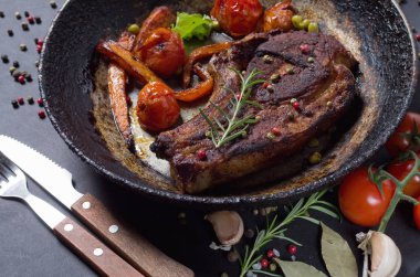 bir tava üzerinde sebzeli ızgara biftek