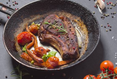 bir tava üzerinde sebzeli ızgara biftek