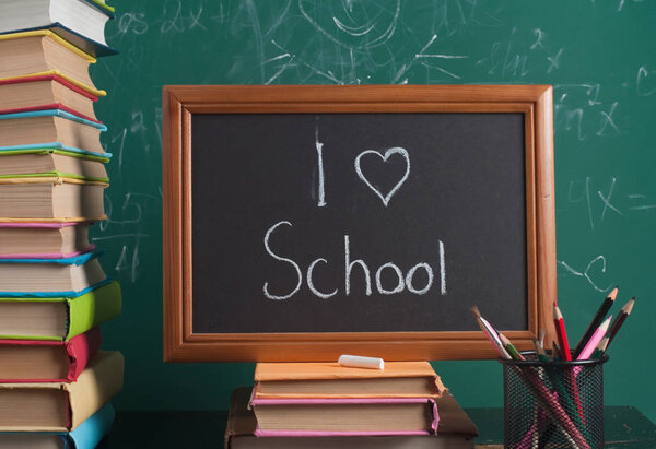 Книги на фоне школьной доски
