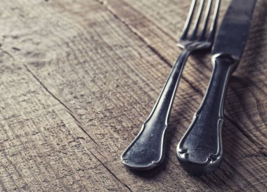 Tahta masadaki eski çatal bıçak takımı.