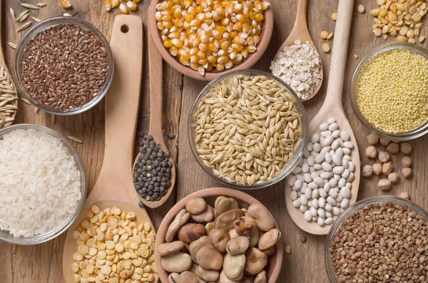 Cereal grains , seeds, beans on wooden background.
