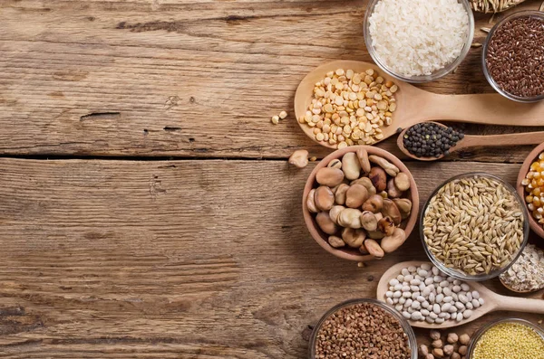 Tahıl taneleri, tohumlar, ahşap arka planda fasulyeler..
