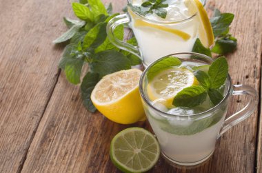 Ahşap arka plan üzerinde soğuk taze limonata içmek