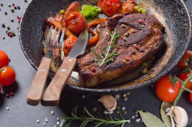 bir tava üzerinde sebzeli ızgara biftek