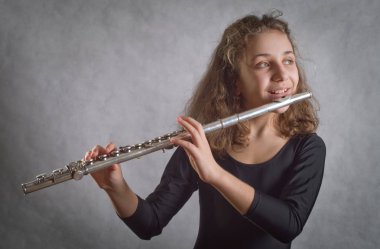 Girl Playing Flute on a gray background clipart