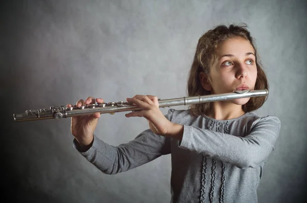 Chica Jugando Flauta Sobre Fondo Gris —  Fotos de Stock
