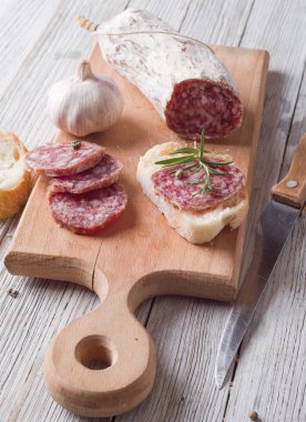 İtalyan salamı ahşap bir masaya dilimlenmiş