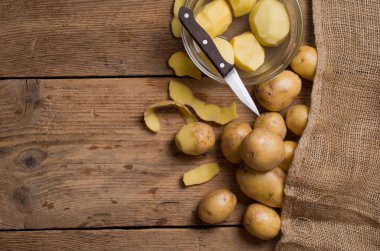 Ahşap bir masa üzerinde soyulmuş patates