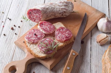 İtalyan salamı ahşap bir masaya dilimlenmiş