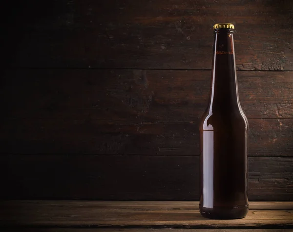 Botella de cerveza sobre un fondo de madera — Foto de Stock