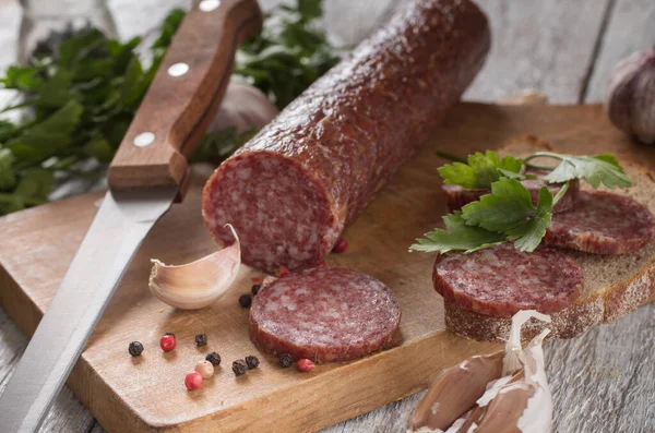 Salame e pão em uma tábua de madeira — Fotografia de Stock